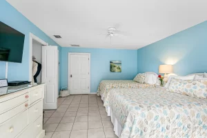 English Garden Bedroom blue and white suite with two beds, closet, and a ceiling fan - Windemere Inn Florida bed and breakfast