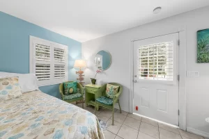 English Garden Bedroom blue and white suite with a sitting area and door to the outdoors - Windemere Inn Florida bed and breakfast