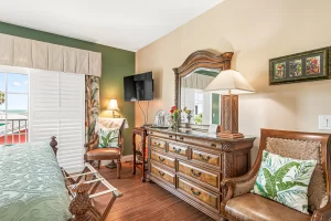 Melbourne Bedroom green and tan suite with a large dresser and chairs - Windemere Inn Florida bed and breakfast