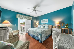 Summer Garden Bedroom blue and white suite with ceiling fan, wicker furniture, and a balcony - Windemere Inn Florida bed and breakfast