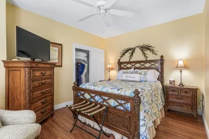 Windsong Bedroom with a queen bed, ceiling fan, tall dresser, and large closet - Windemere Inn Florida bed and breakfast