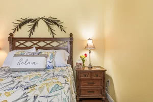 Windsong Bedroom nightstand and queen bed - Windemere Inn Florida bed and breakfast