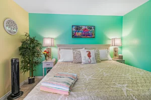 Windsong Bedroom green and yellow suite with a fan and a queen bed - Windemere Inn Florida bed and breakfast