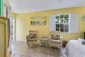 Windsong Bedroom green and yellow suite with a wicker rocking chairs - Windemere Inn Florida bed and breakfast