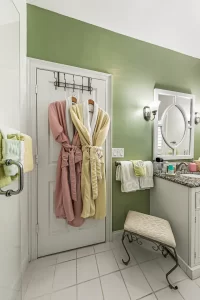 Forever Spring Bathroom green and white bathroom with robes and a vanity - Windemere Inn Florida bed and breakfast