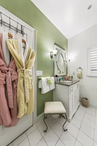 Forever Spring Bathroom green and white bathroom with robes and a granite vanity - Windemere Inn Florida bed and breakfast