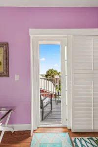 Forever Spring Bedroom pink and white suite balcony door with an ocean view - Windemere Inn Florida bed and breakfast