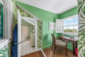 Lookout Work Station green and white suite wooden desk, window, and entrance to bathroom - Windemere Inn Florida bed and breakfast