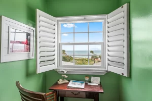 Lookout Work Station green and white suite with a desk and a window with an ocean view - Windemere Inn Florida bed and breakfast