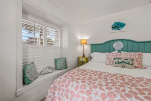 North Beach Bedroom orange and white suite with a king bed and window with ocean view - Windemere Inn Florida bed and breakfast