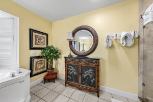 Seabreeze Bathroom yellow and white suite with a jetted tub, tiled shower, and large mirror above a cupboard - Windemere Inn Florida bed and breakfast