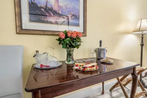 Seabreeze Bedroom yellow and white suite front table with fruit tray and wine - Windemere Inn Florida bed and breakfast